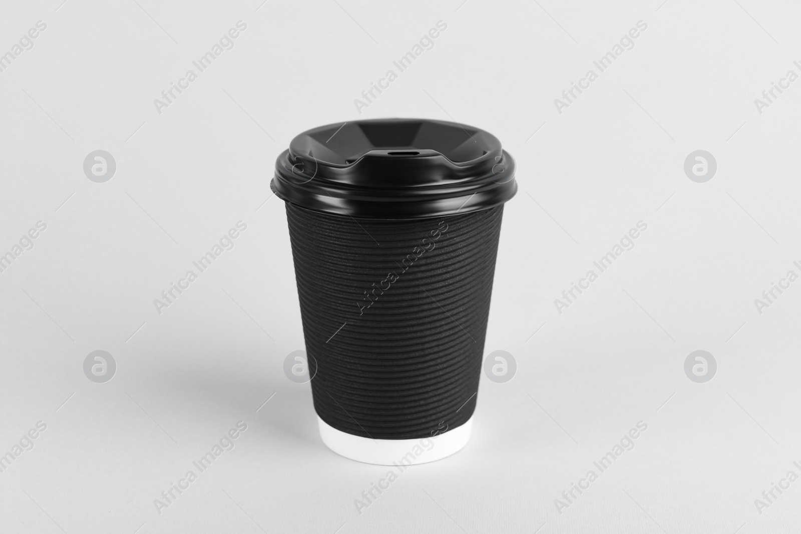 Photo of Black paper cup with plastic lid on light background. Coffee to go