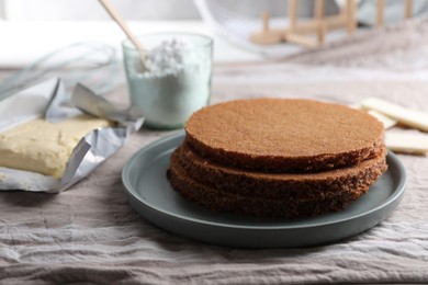 Delicious homemade sponge cakes and ingredients on grey tablecloth