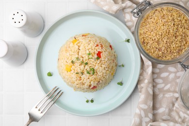 Delicious bulgur with vegetables and microgreens served on table, flat lay