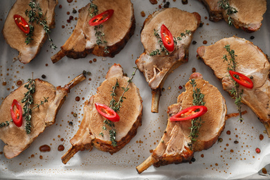 Photo of Delicious roasted ribs in baking tray, flat lay