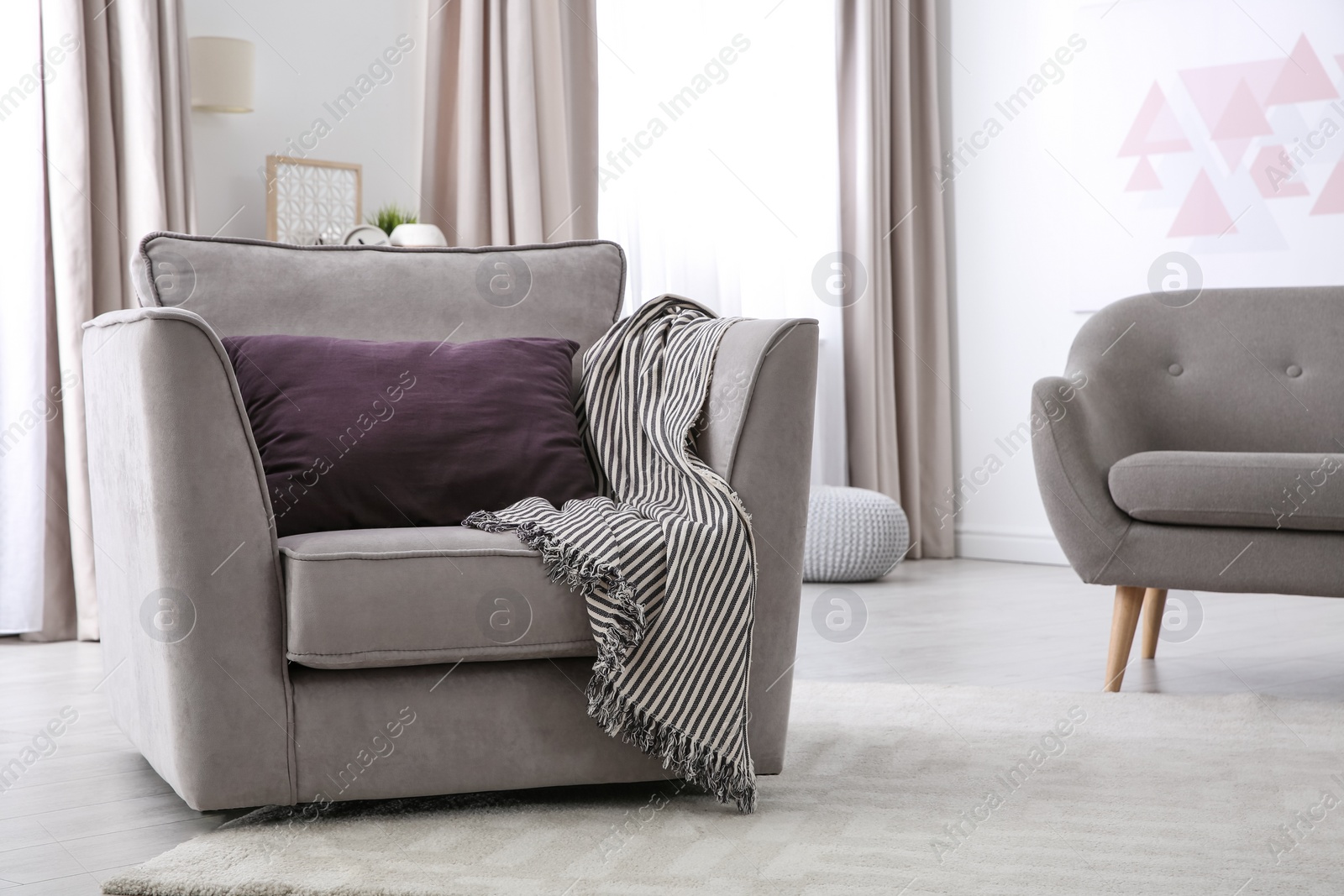 Photo of Comfortable armchair with soft cushion in modern living room interior. Space for text