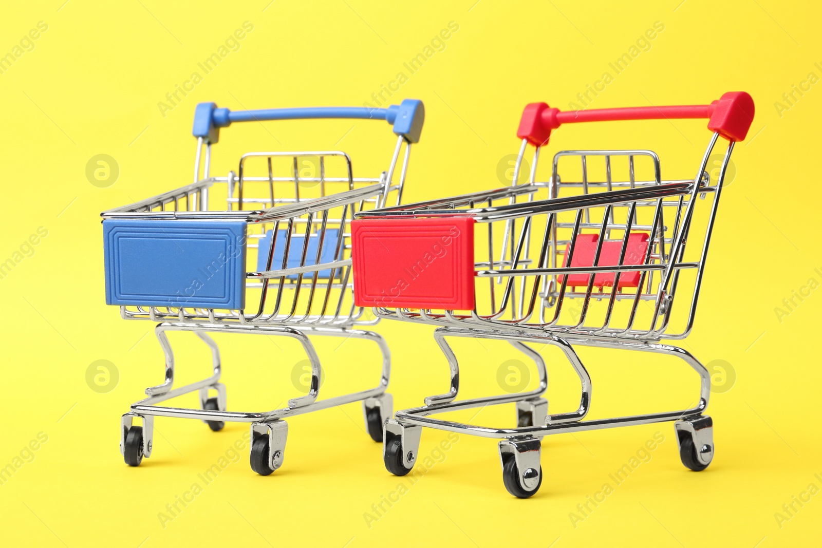 Photo of Empty shopping trolleys with handles on color background