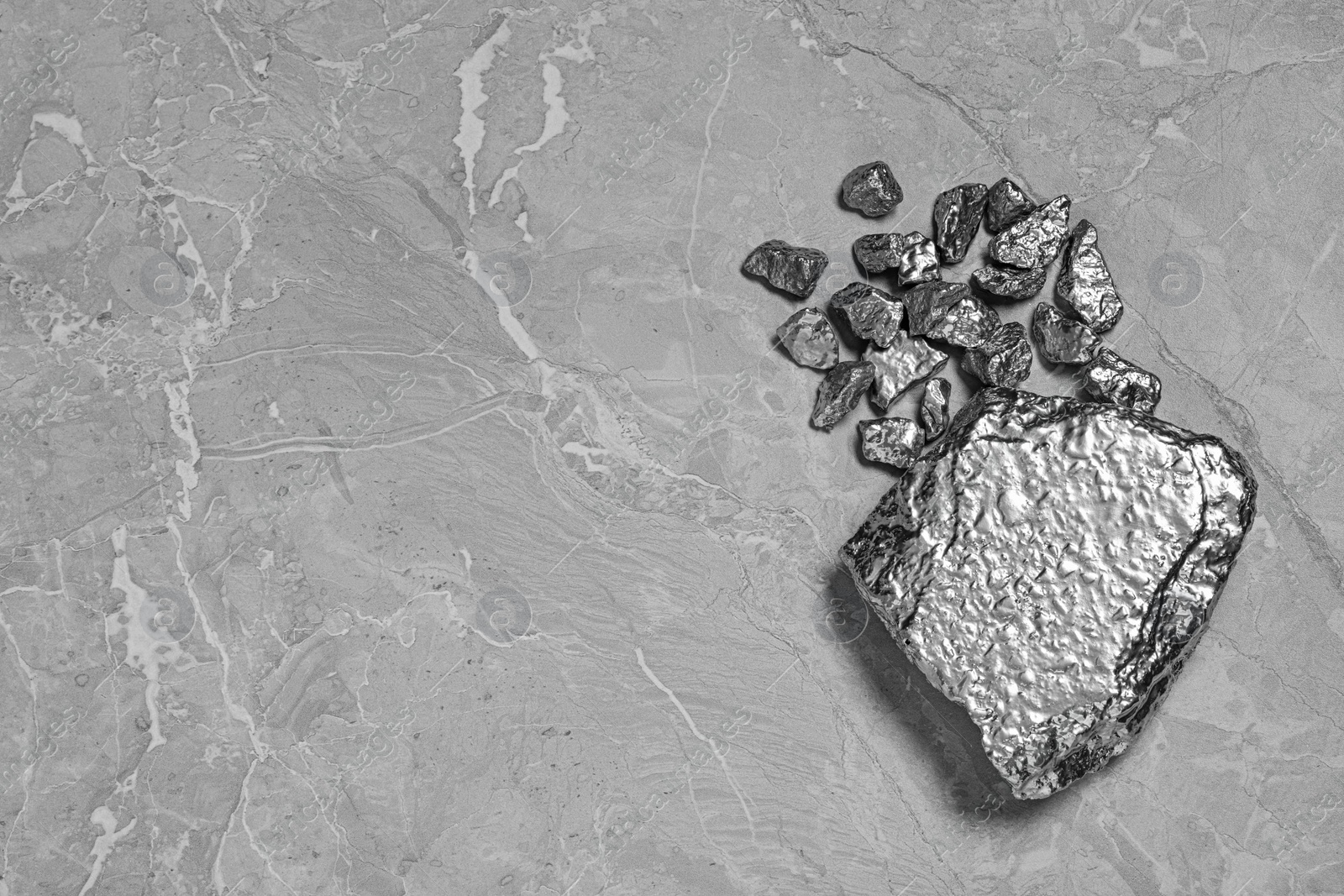 Photo of Pile of silver nuggets on light grey table, flat lay. Space for text