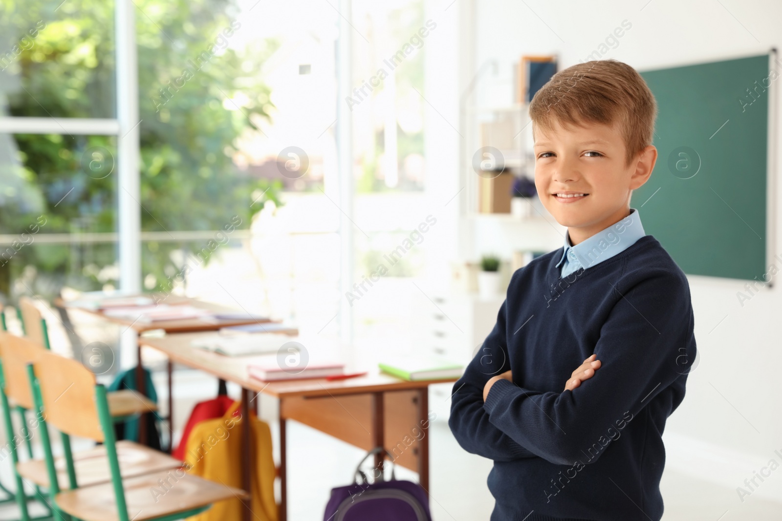 Photo of Little boy in classroom. Stylish school uniform