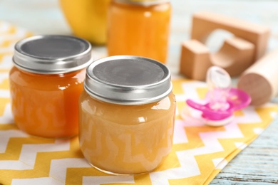 Jars with healthy baby food on table