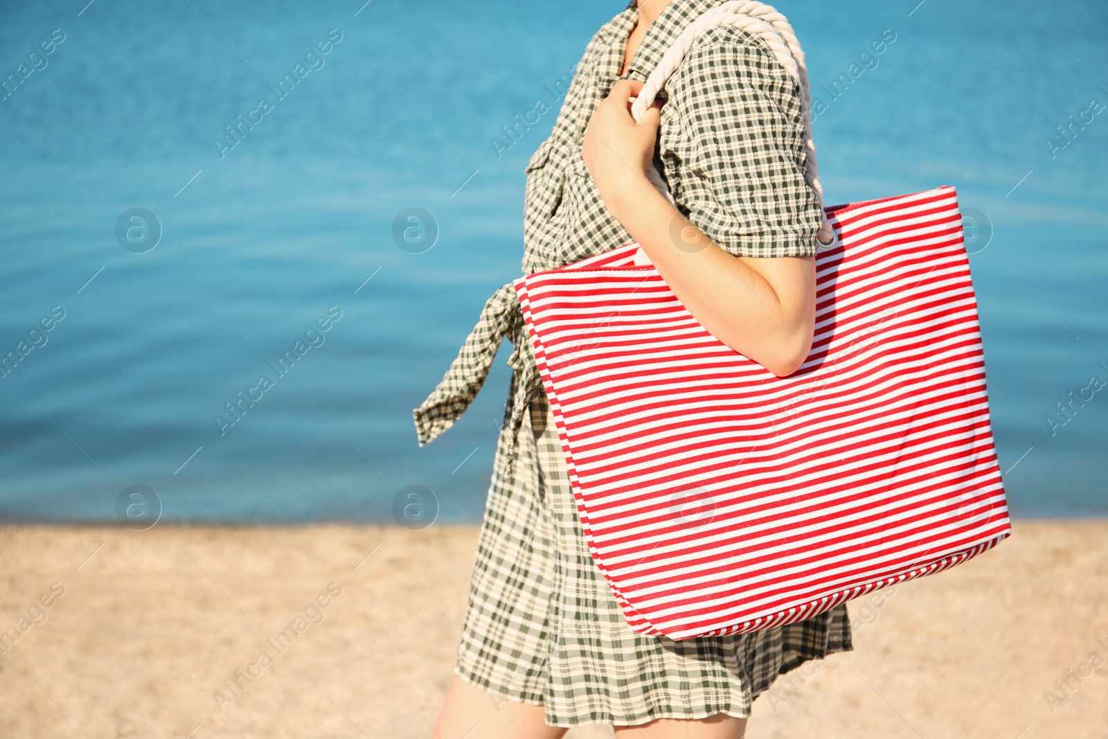 Photo of Woman holding bag on beach. Summer vacation