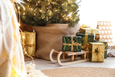 Many different gifts under Christmas tree indoors