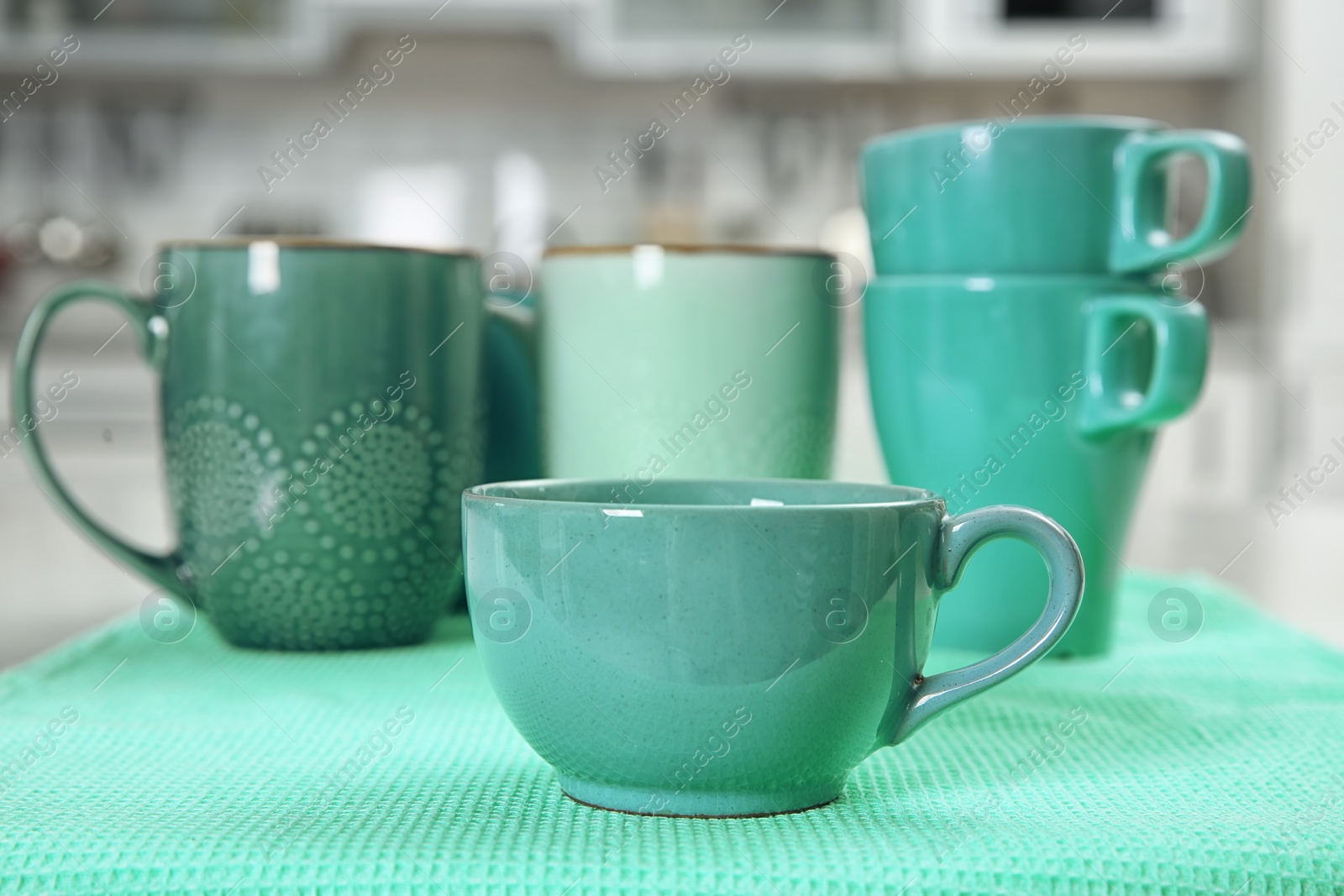 Photo of Ceramic cups in different mint color shades on table