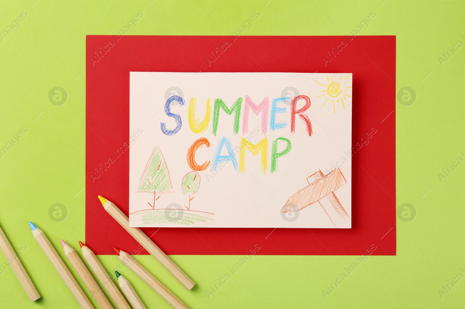 Photo of Paper with written text SUMMER CAMP, drawings and different pencils on color background, flat lay