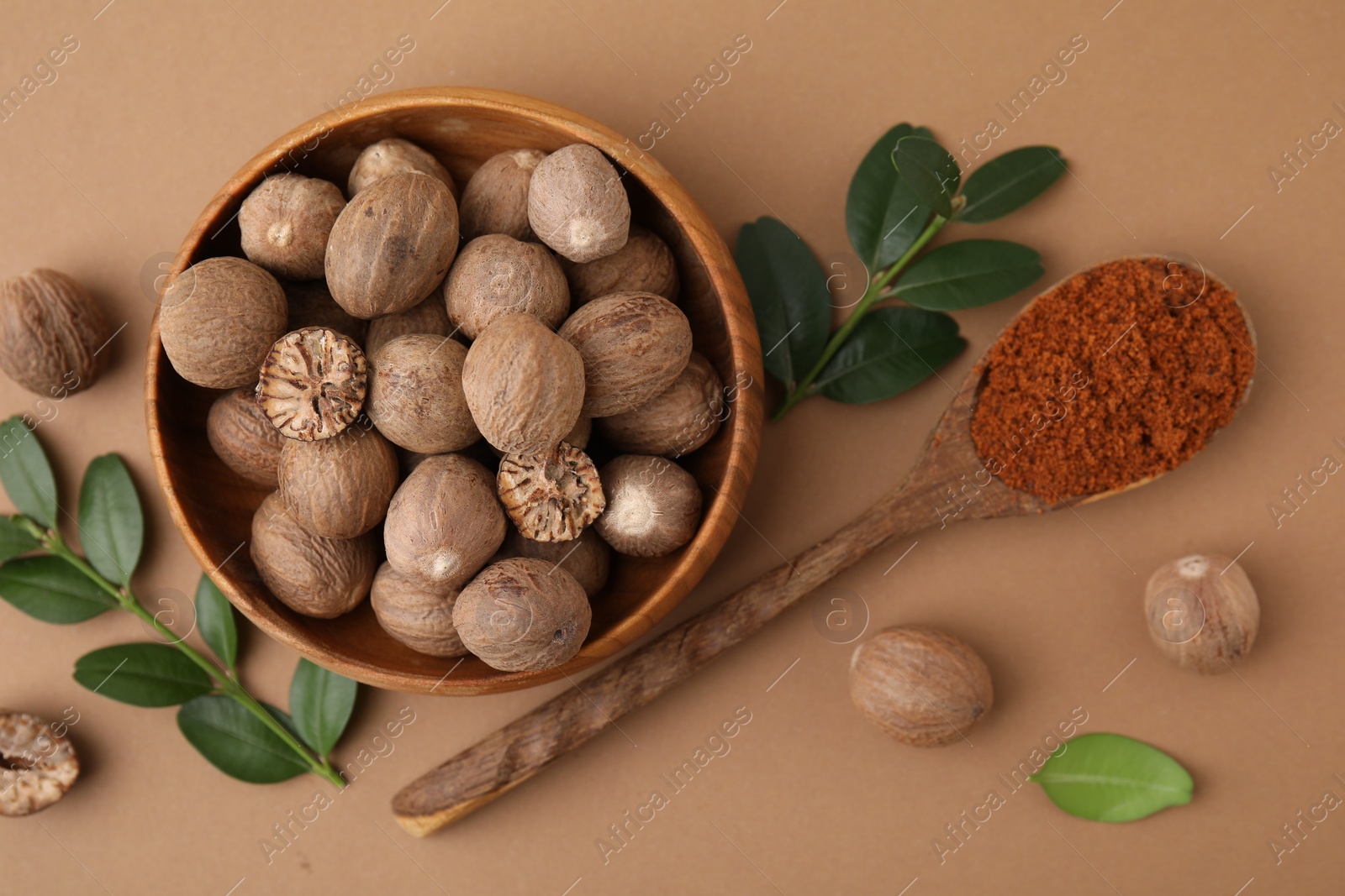 Photo of Flat lay composition with nutmegs on light brown background