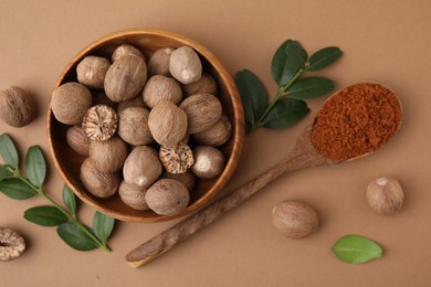 Flat lay composition with nutmegs on light brown background