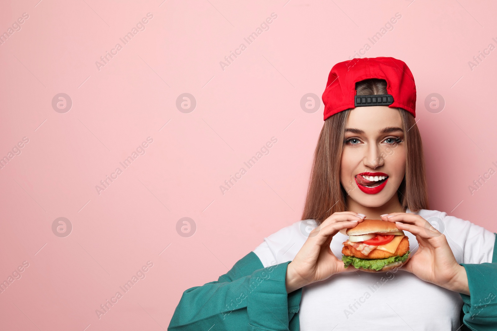 Photo of Pretty woman with tasty burger on color background. Space for text