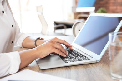 Woman using video chat on laptop in home office, closeup. Space for text