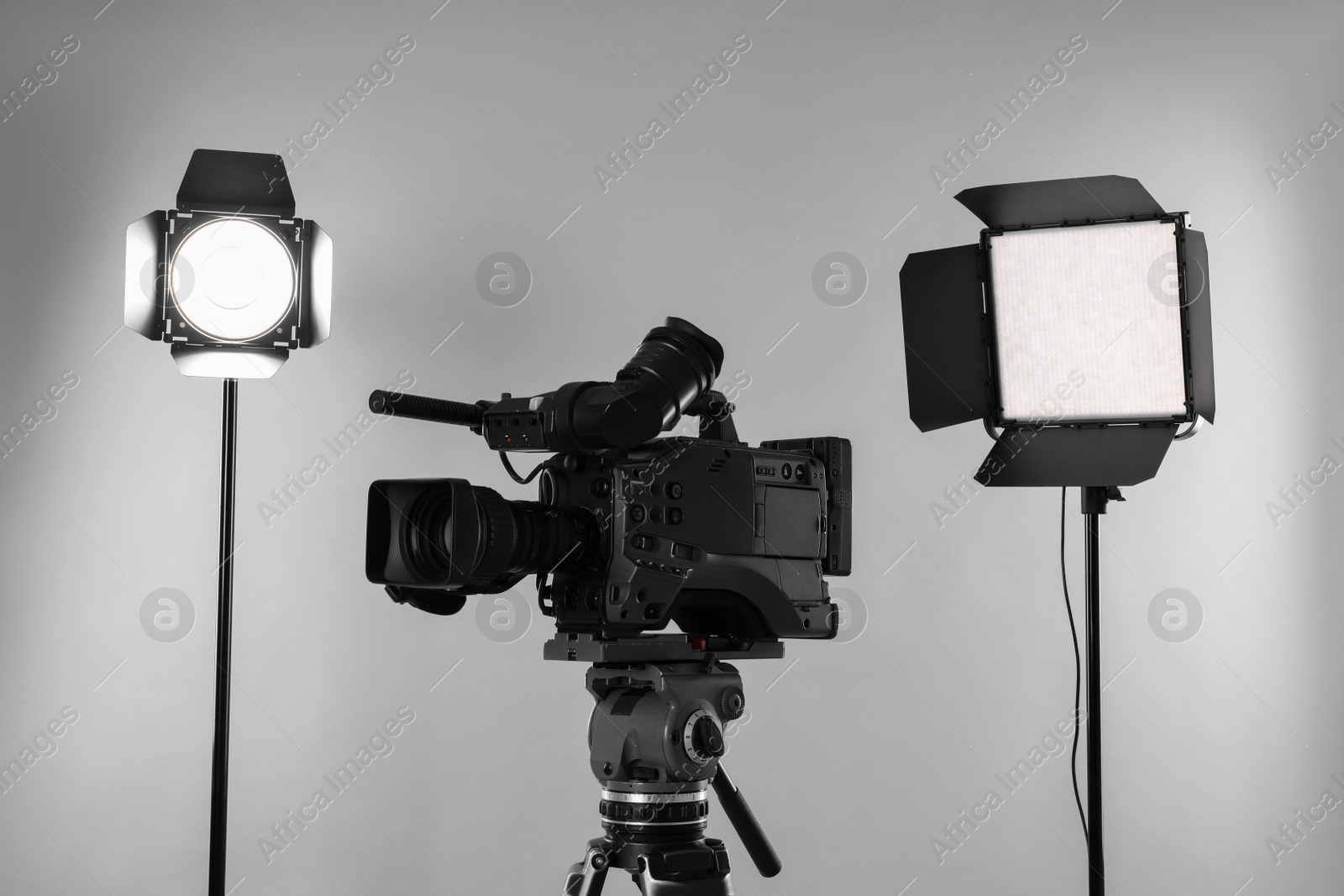 Photo of Professional video camera and lighting equipment on white background