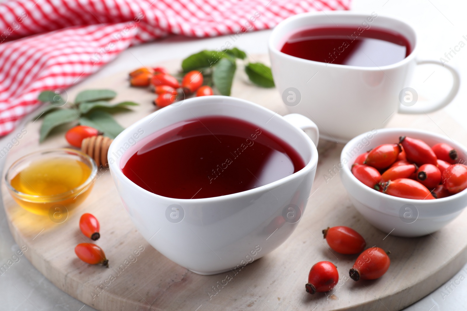 Photo of Fresh rose hip tea and berries on light table