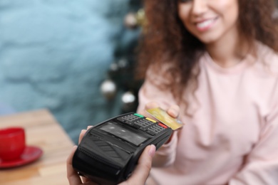 Photo of Client using credit card machine for non cash payment indoors, closeup