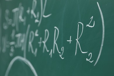 Different math formulas written with chalk on green board