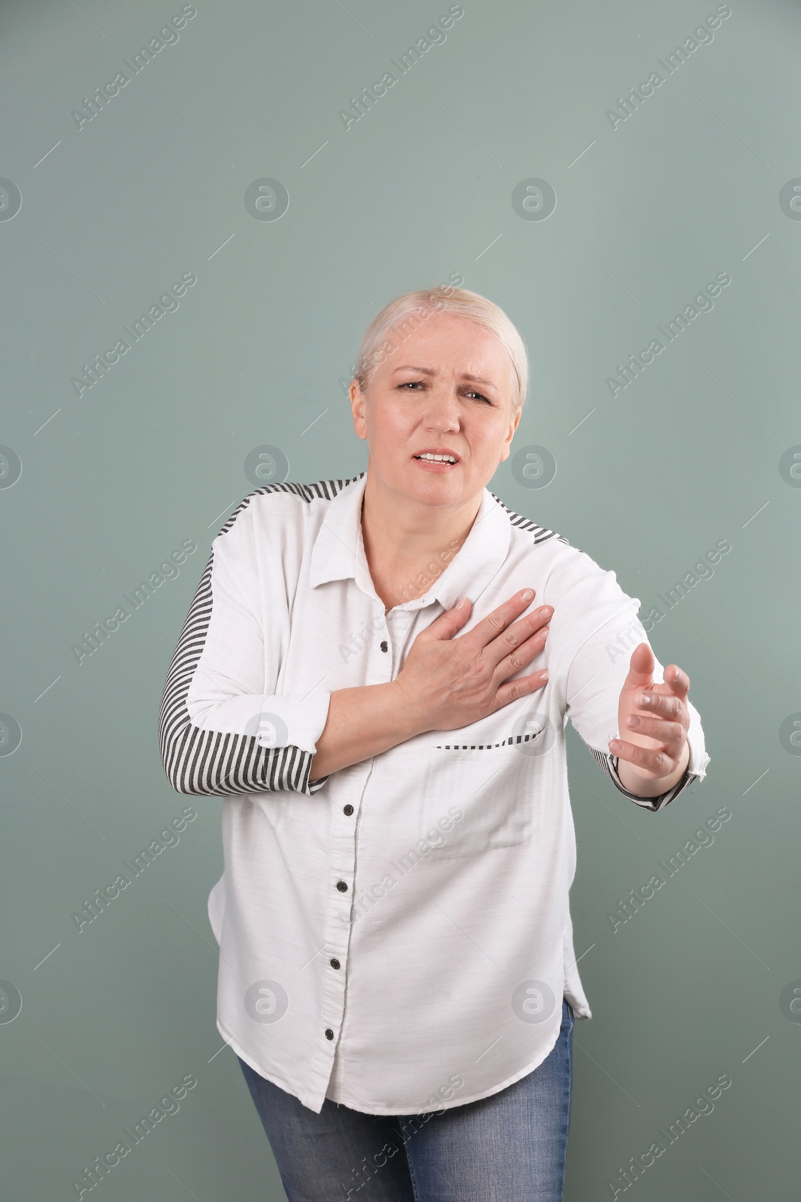 Photo of Mature woman having heart attack on color background