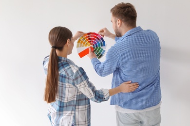 Photo of Young couple with color palette on white background