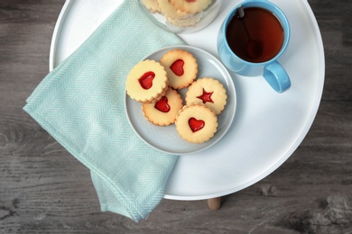 Photo of Traditional Christmas Linzer cookies with sweet jam on table, top view