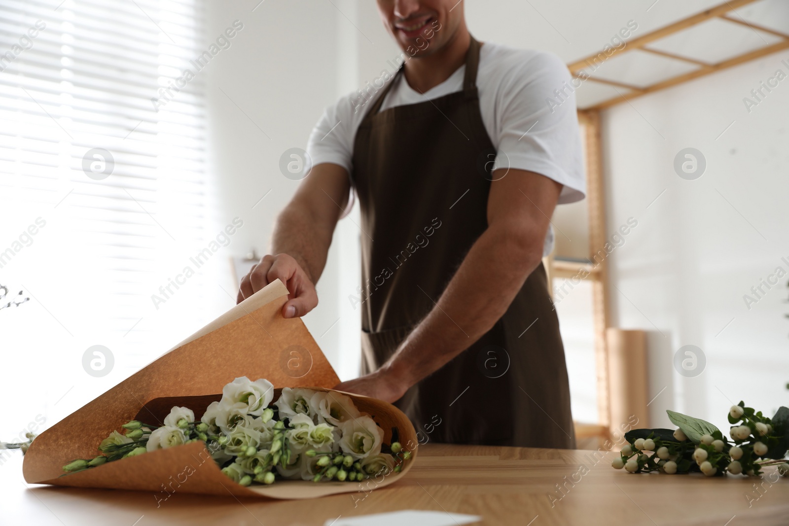 Photo of Florist making beautiful bouquet in workshop, closeup