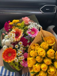 Photo of Woman with different bouquets of beautiful flowers in car, closeup