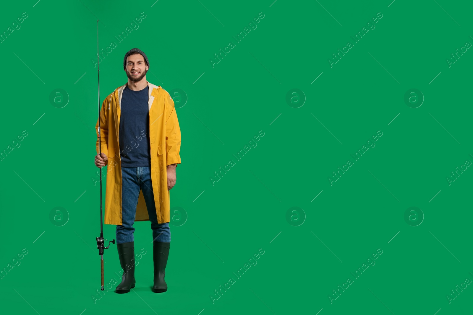 Photo of Fisherman with fishing rod on green background, space for text