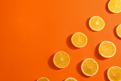 Photo of Slices of delicious oranges on color background, flat lay. Space for text