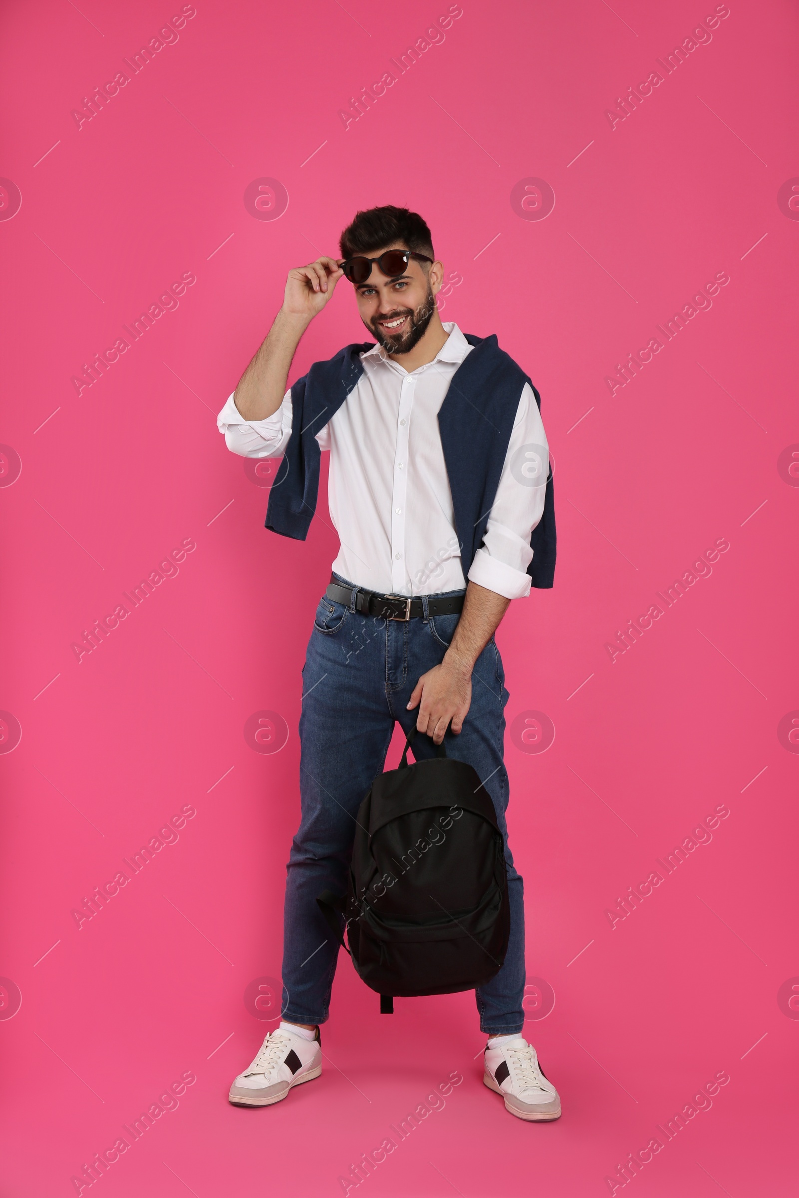 Photo of Young man with stylish backpack on pink background