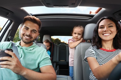 Photo of Happy family traveling by car on summer day