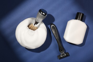 Photo of Set of men's shaving tools and foam on blue background, flat lay