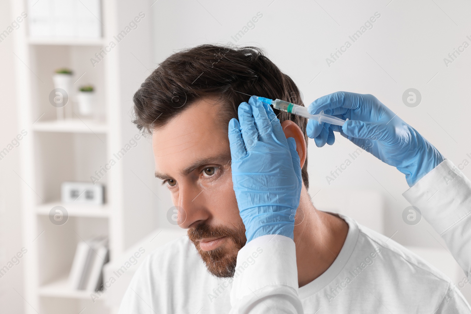 Photo of Trichologist giving injection to patient in clinic, closeup