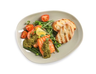 Photo of Tasty cooked salmon with pesto sauce and fresh salad on white background, top view