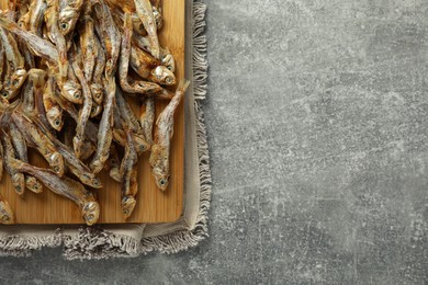 Delicious dried anchovies on grey table, top view. Space for text