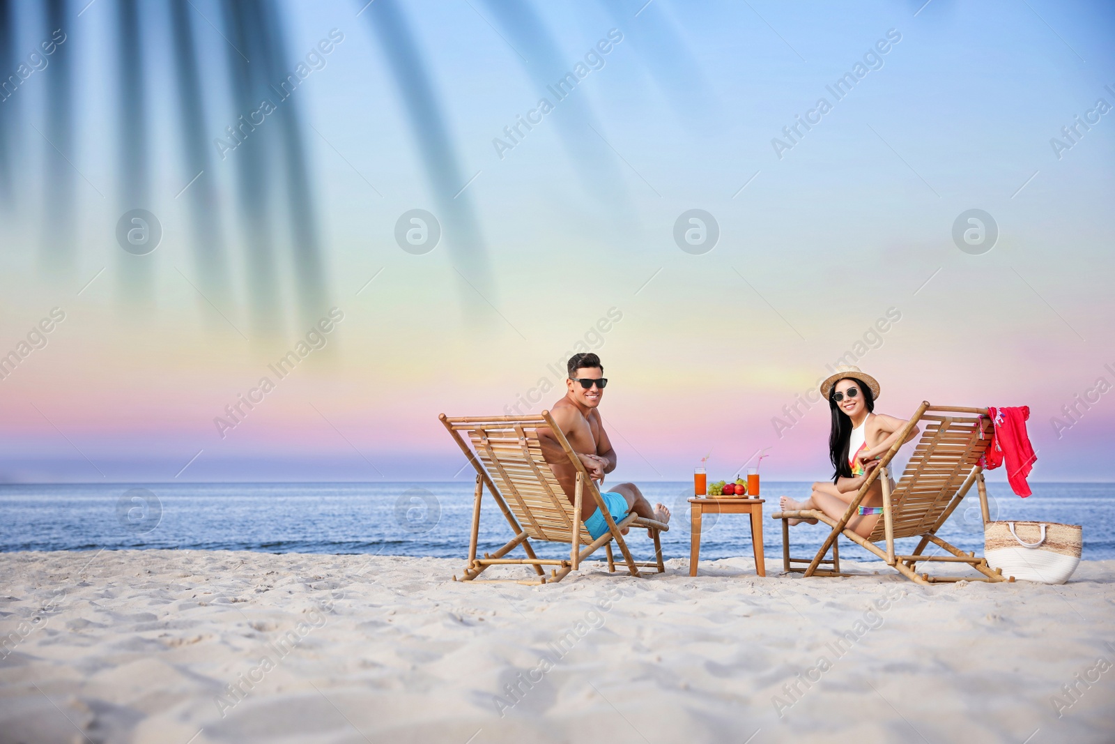 Photo of Couple resting on sunny beach at resort