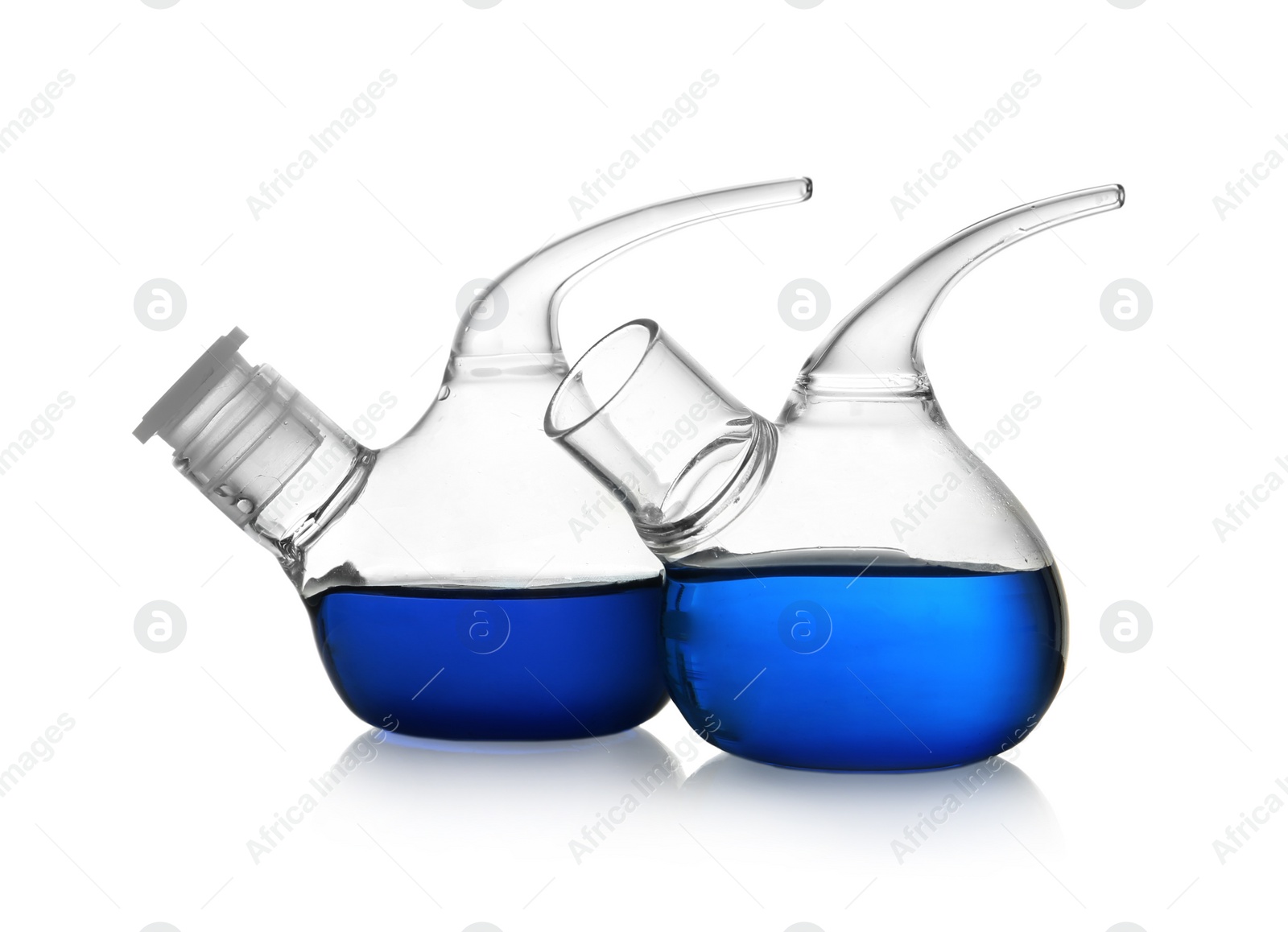 Photo of Retort flasks with blue liquid on white background. Laboratory glassware