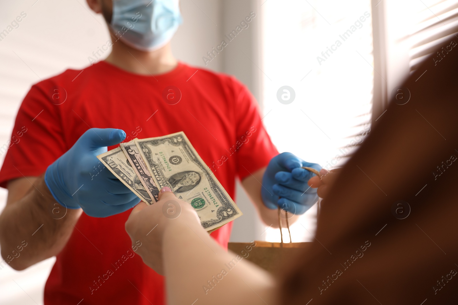 Photo of Deliveryman receiving tips from woman indoors, closeup