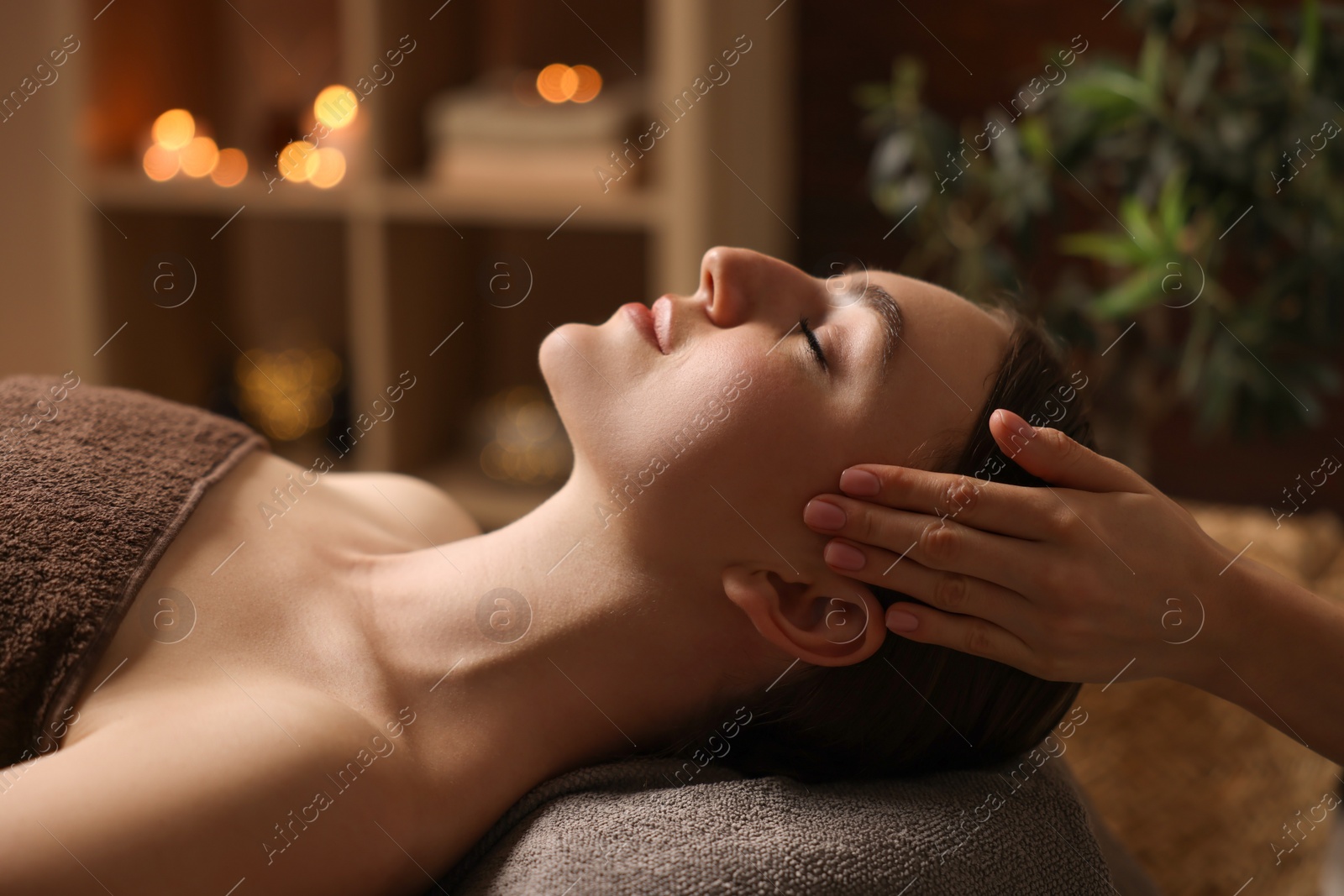 Photo of Spa therapy. Beautiful young woman lying on table during massage in salon