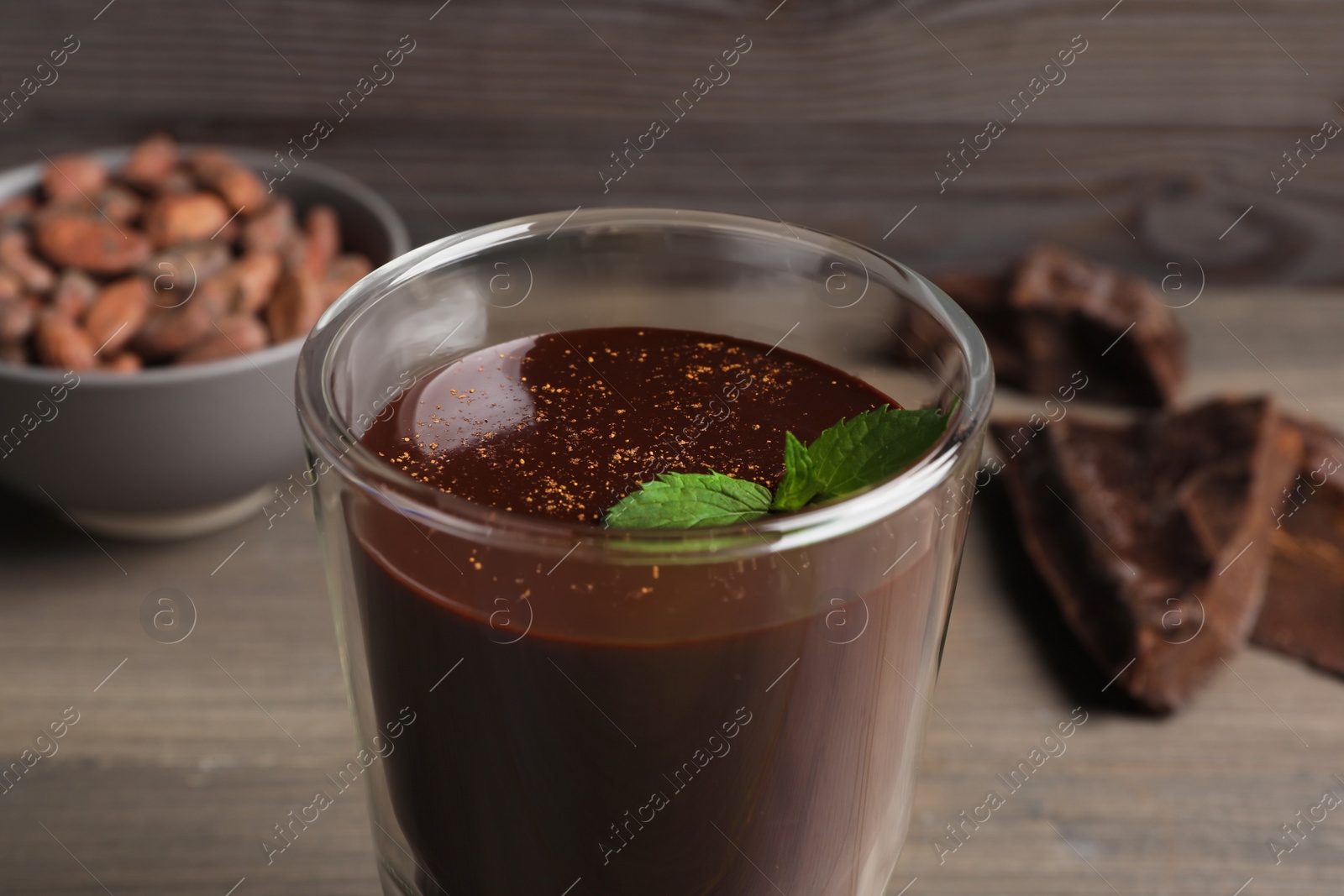 Photo of Glass of delicious hot chocolate with fresh mint on wooden table, closeup