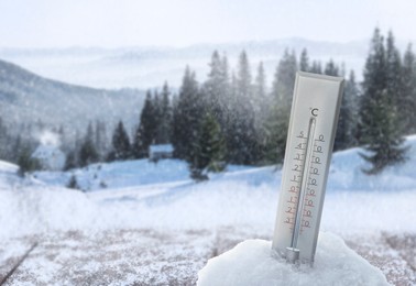 Image of Thermometer in snow showing temperature below zero outdoors on winter day