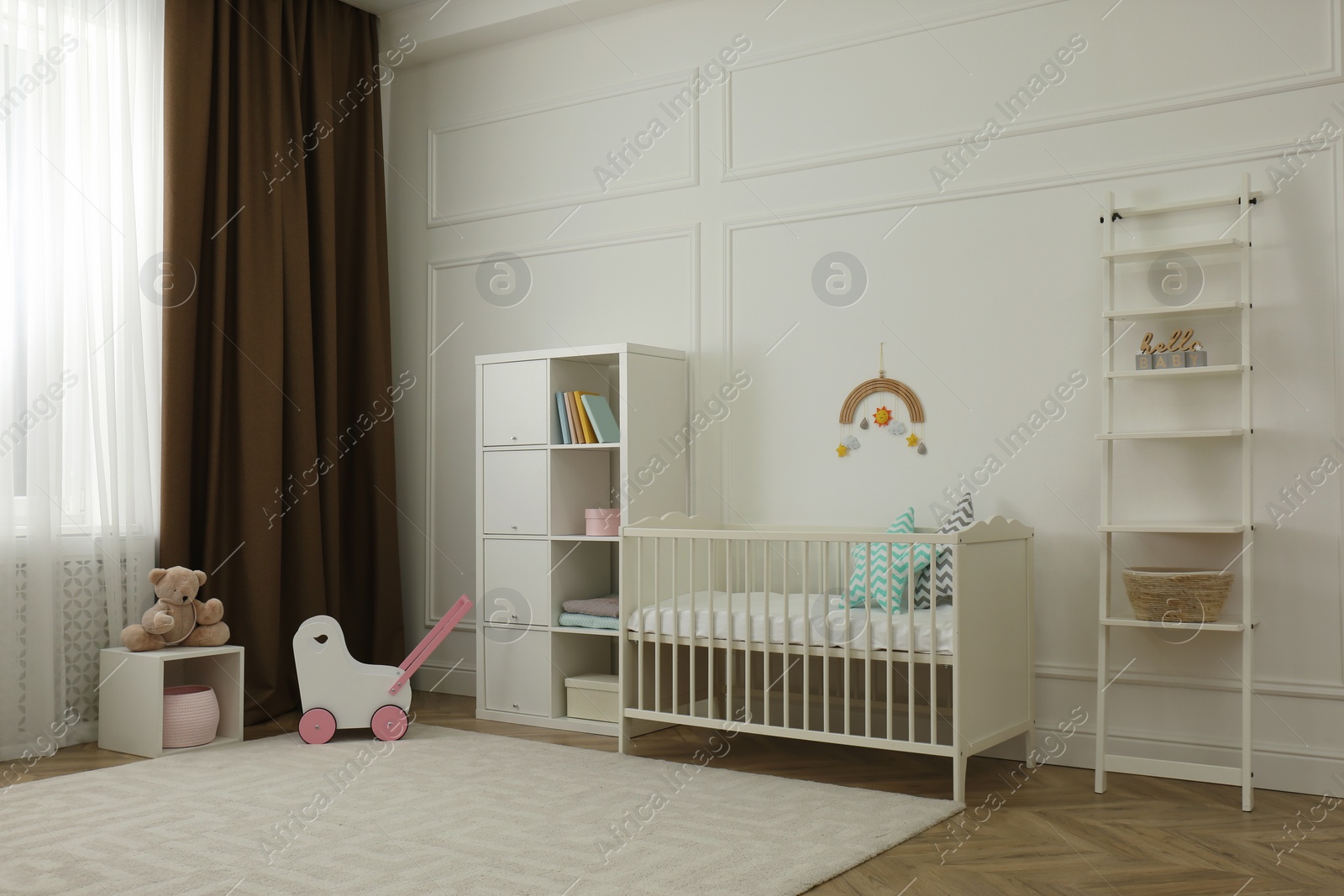 Photo of Cute baby room interior with stylish furniture and toys