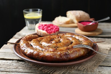 Photo of Tasty homemade sausages served on wooden table