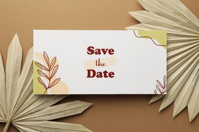 Beautiful card with Save the Date phrase and leaves on beige background, top view