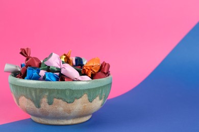 Photo of Candies in different wrappers on color background, space for text