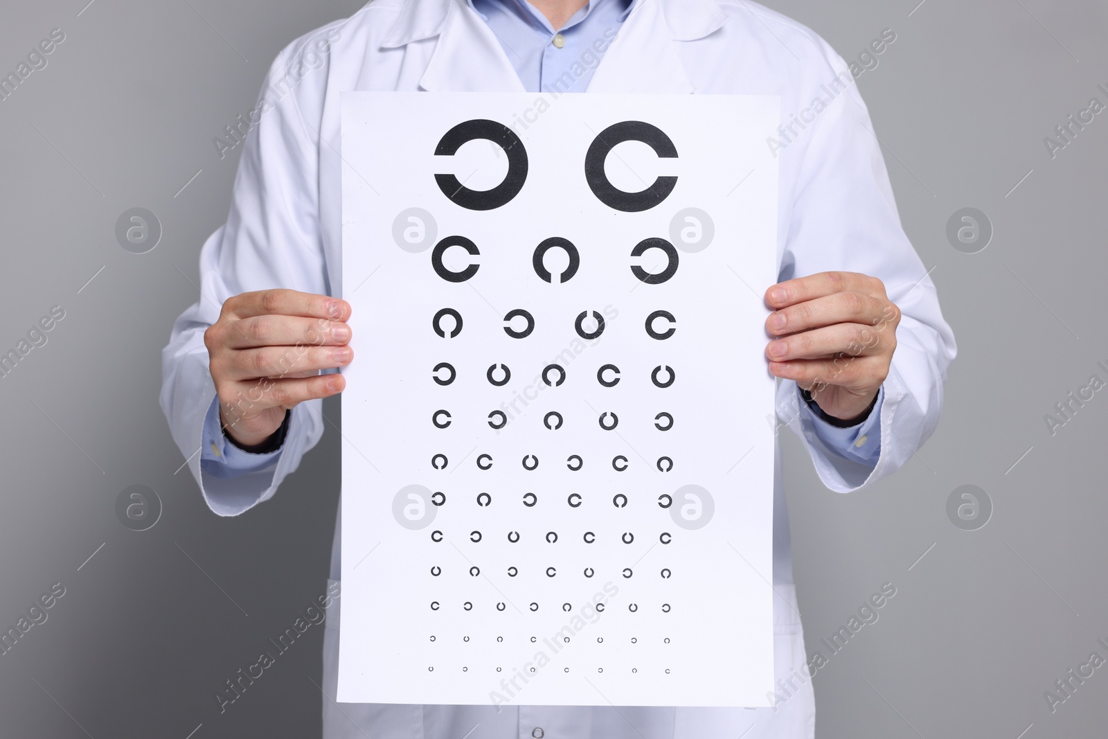 Photo of Ophthalmologist with vision test chart on gray background, closeup