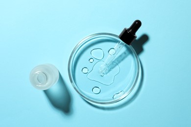 Petri dish, pipette and bottle on light blue background, flat lay