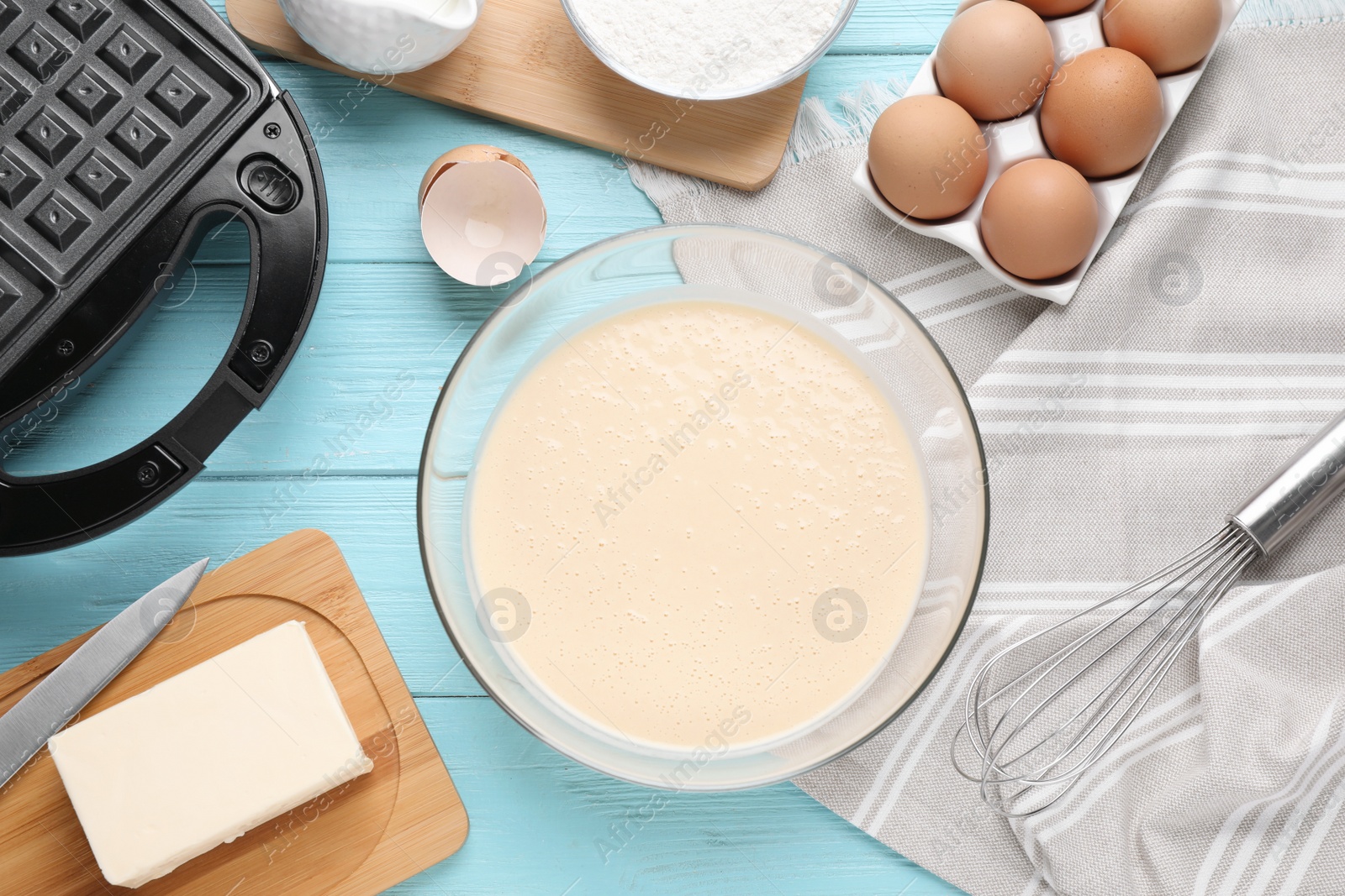 Photo of Flat lay composition with ingredients for cooking Belgian waffles on light blue wooden table