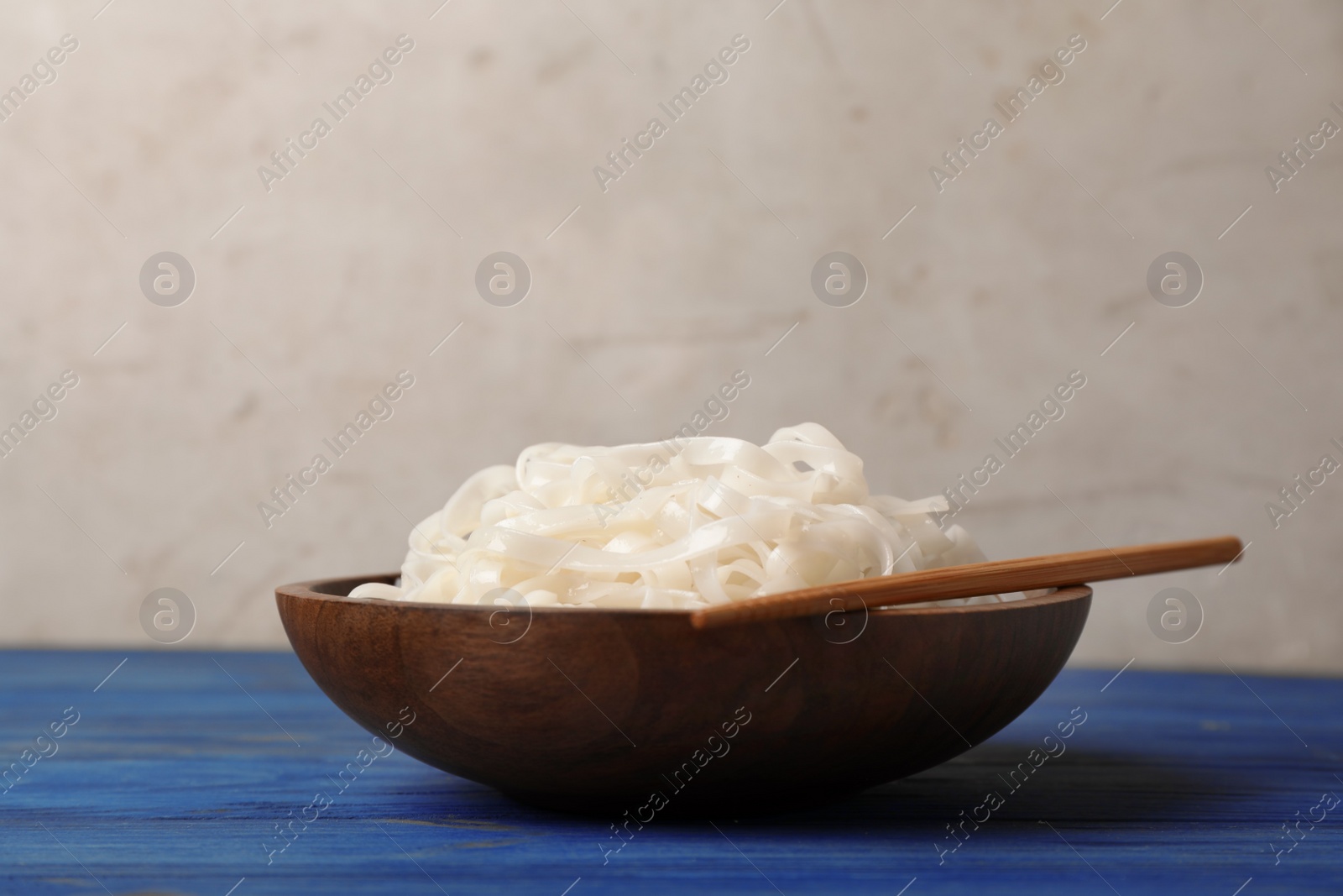 Photo of Bowl with rice noodles on wooden table