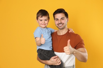 Photo of Portrait of dad and his son on color background