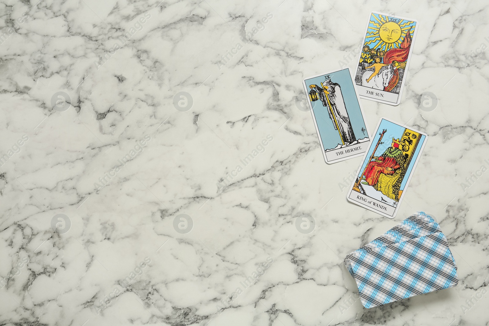 Photo of Tarot cards on white marble table, flat lay. Space for text